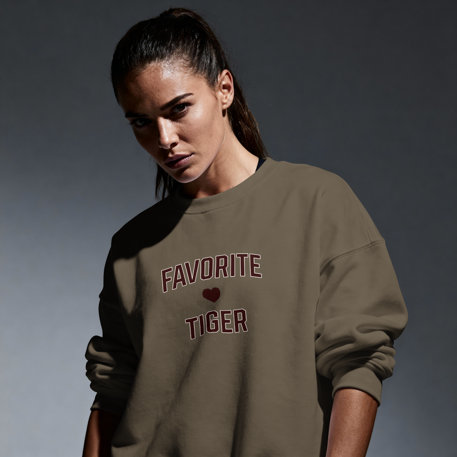 Woman in oversized streetwear sweatshirt with 'Favorite Tiger' and heart graphic on front