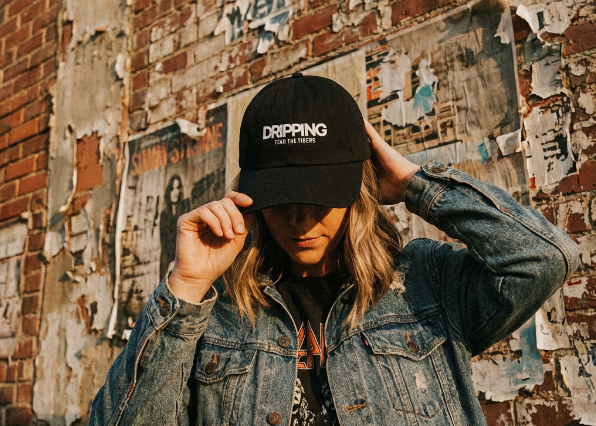 Streetwear look with a woman in a black 'Dripping Fear the Tigers' cap and denim jacket