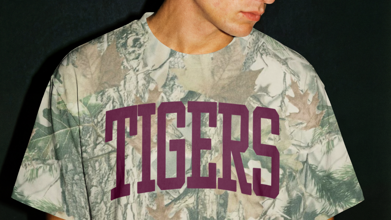 Person wearing a camouflage t-shirt with 'TIGERS' printed in maroon.