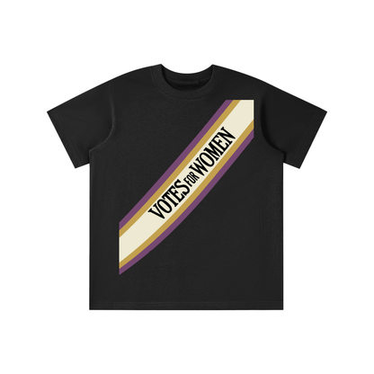 A black short-sleeve crewneck t-shirt featuring a diagonal graphic stripe across the chest with the text 'VOTES FOR WOMEN' in black, bordered by purple and gold.
