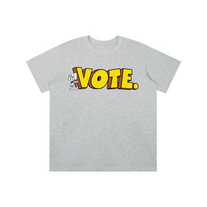 A light heather gray short-sleeve t-shirt with a graphic on the chest featuring the word 'VOTE.' in bold yellow comic-style letters outlined in red, with a small cartoon dog character to the left of the text.